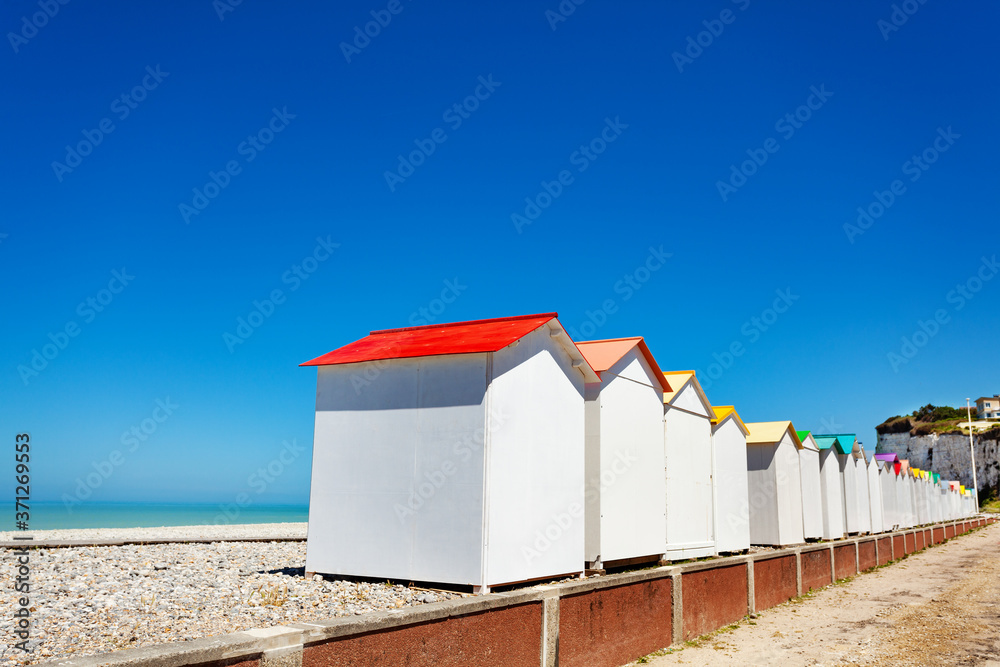 Panorama of Wooden cabins and kiosks on Etretat, France beach over sea with blue sky