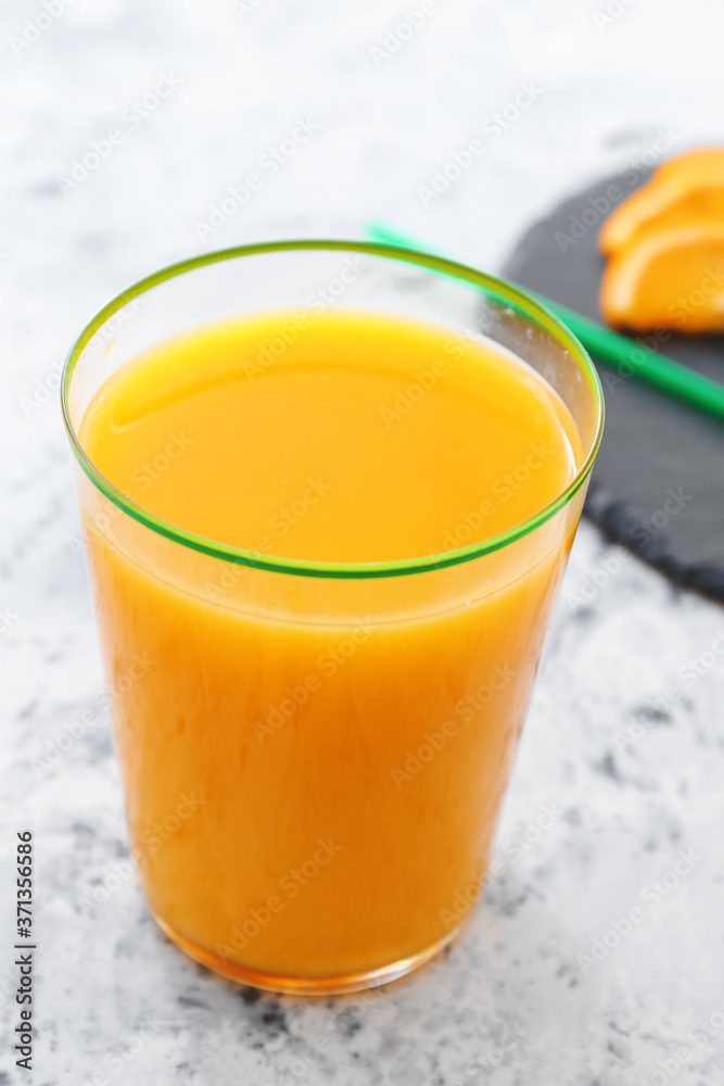 Glass of fresh orange juice on table