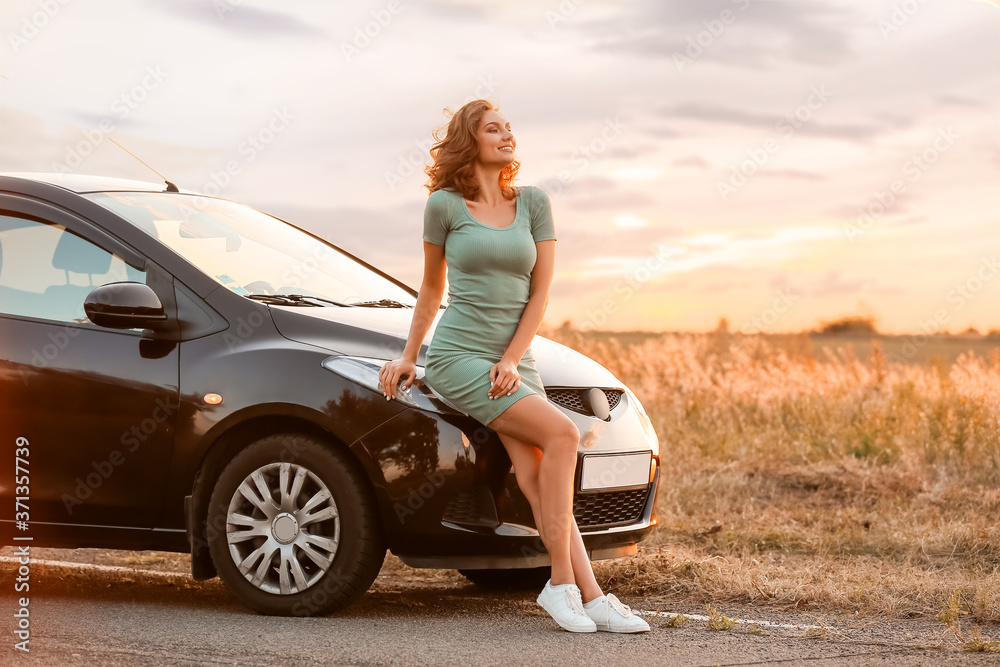 Young woman near car in countryside