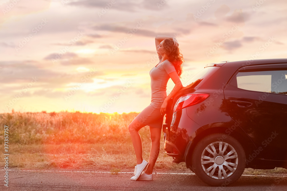 Young woman near car in countryside