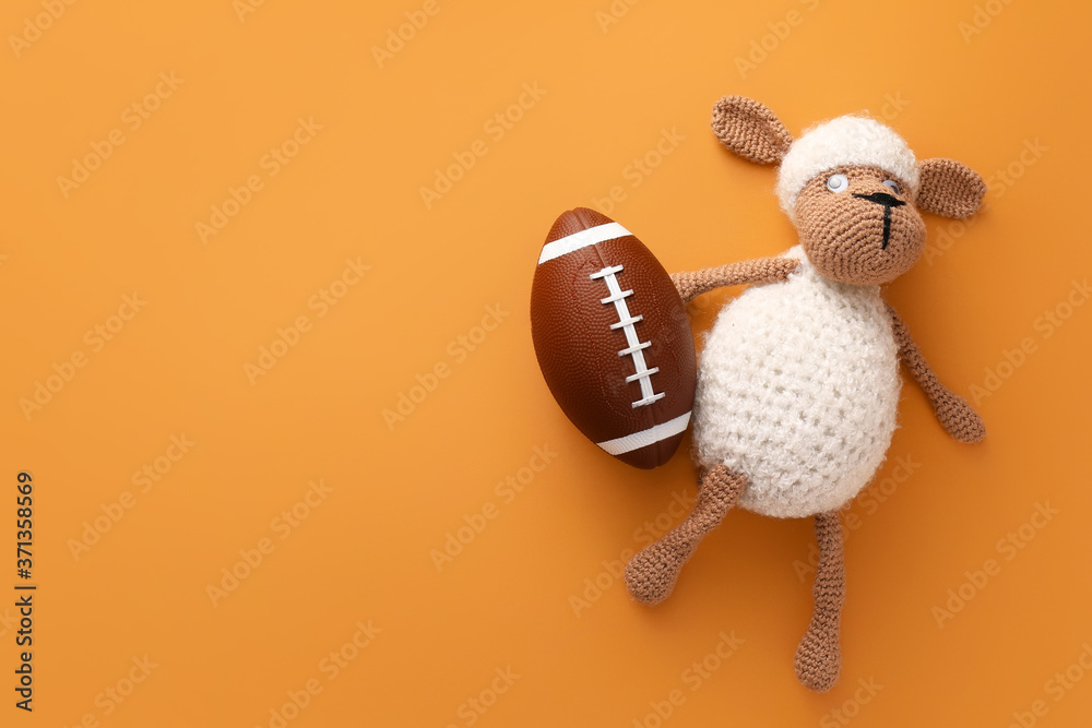 Rugby ball with toy on color background