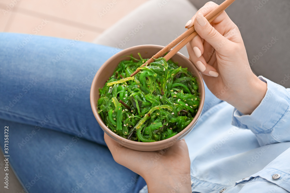 女人在吃美味的海藻沙拉，特写镜头