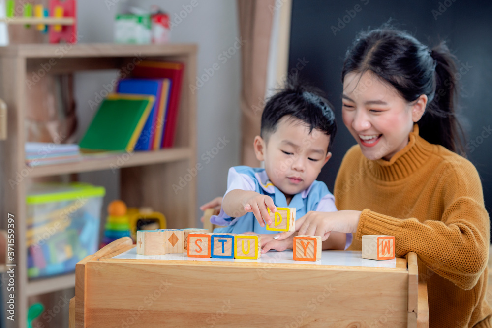 学前班的亚洲学生在教室里用信箱和老师一起做一个学习单词