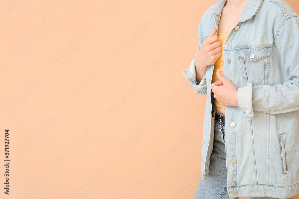 Beautiful young woman in jeans clothes on color background