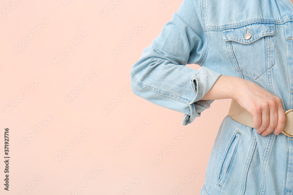 Beautiful young woman in jeans clothes on color background