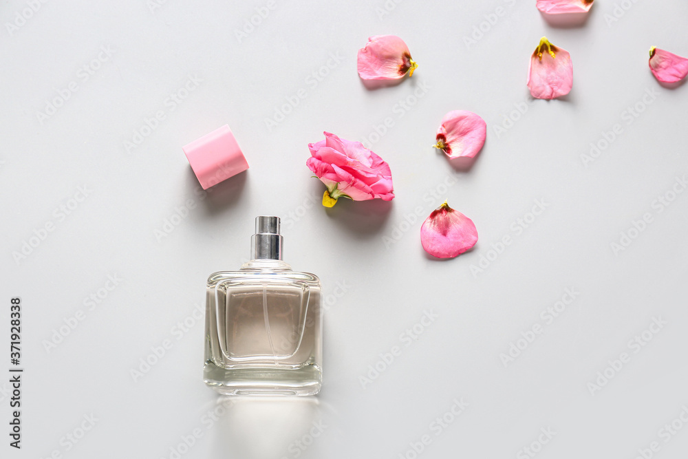 Bottle of floral perfume on light background