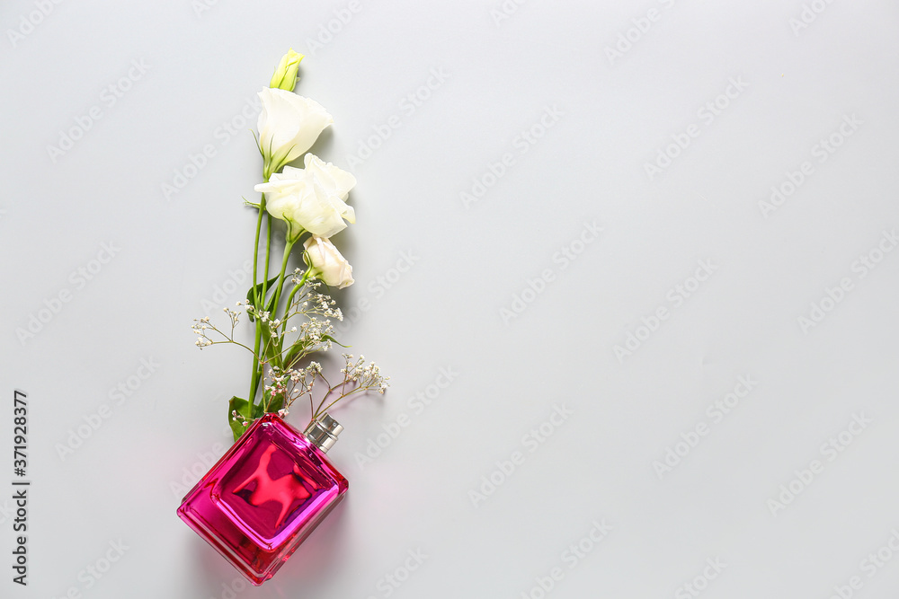 Bottle of floral perfume on light background