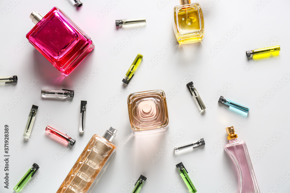 Bottles of different perfumes on light background