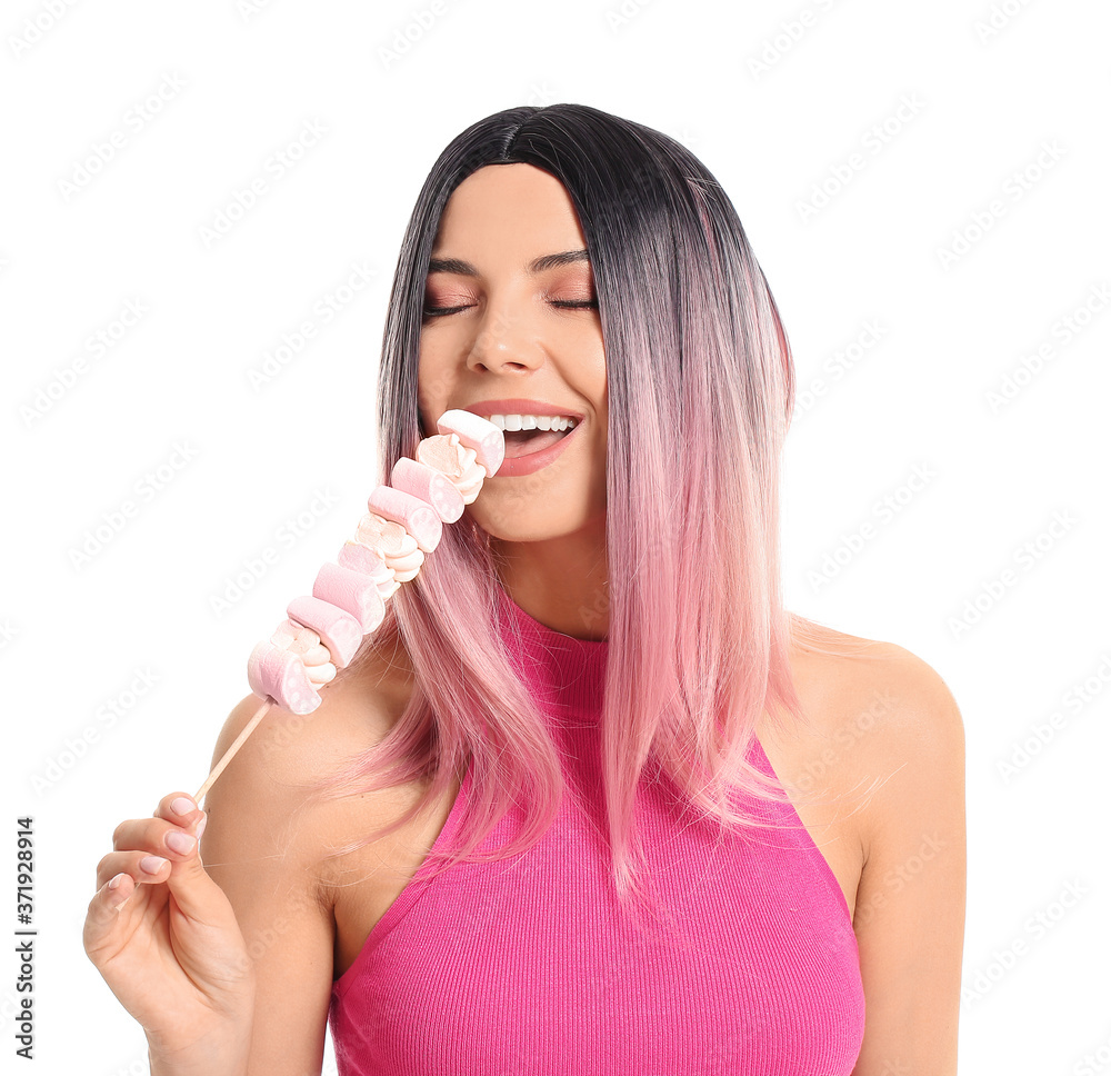 Beautiful young woman in wig and with marshmallow on white background