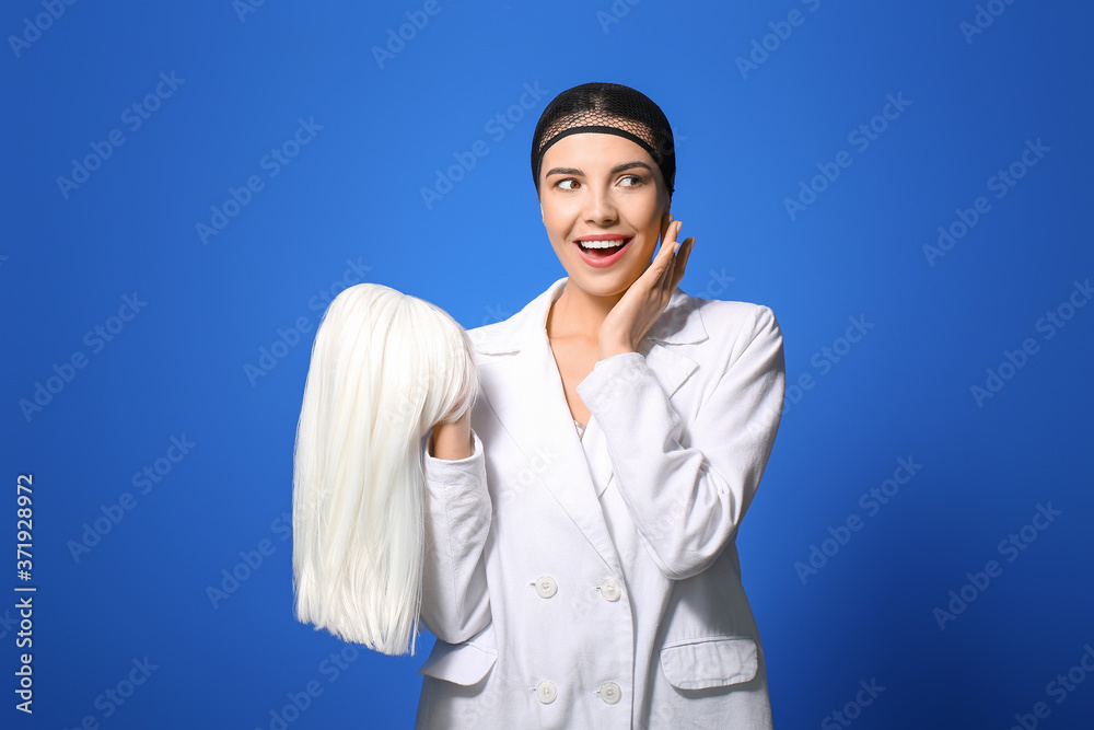 Beautiful young woman with wig on color background