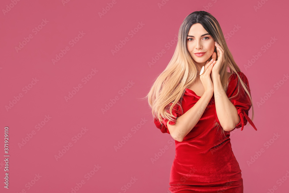 Beautiful young woman in wig on color background