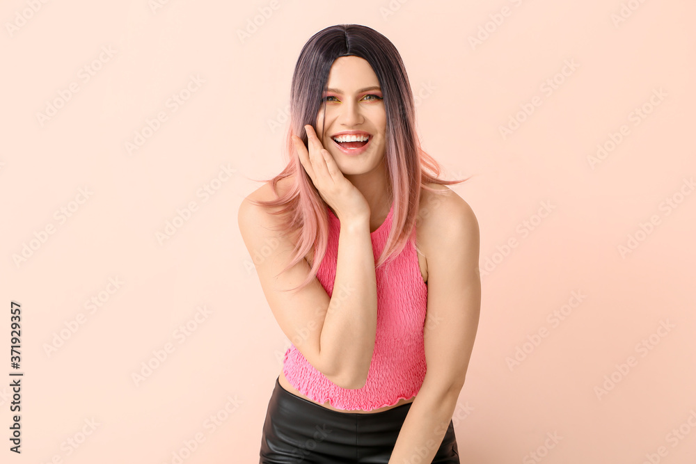 Beautiful young woman in wig on color background