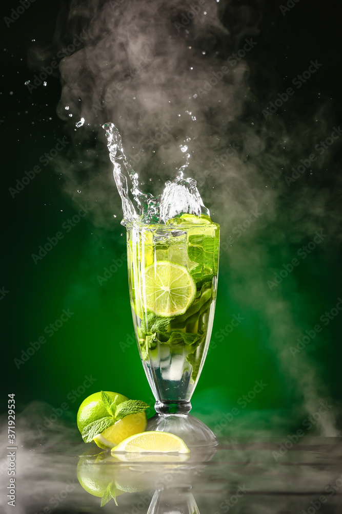 Glass of fresh mojito with splash on dark background