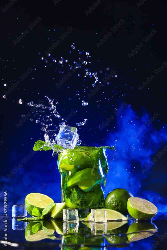 Glass of fresh mojito with splash on dark background