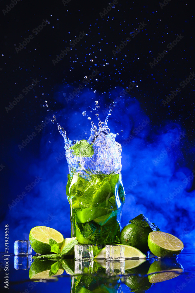 Glass of fresh mojito with splash on dark background