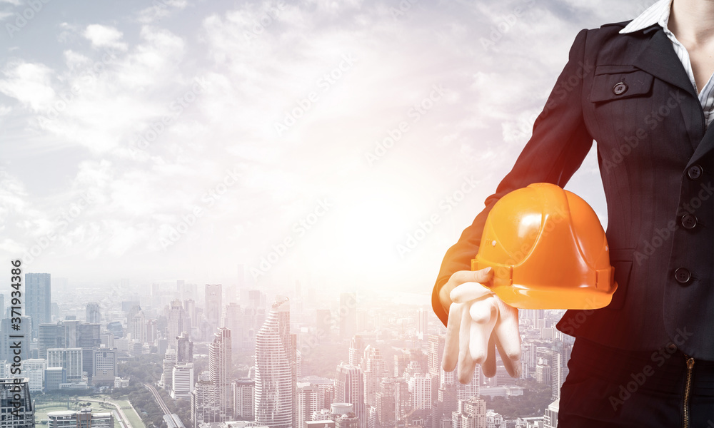 Woman architect holding safety helmet