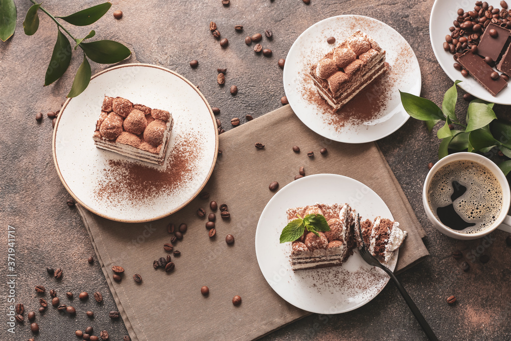 Plates with tasty tiramisu and coffee on dark background