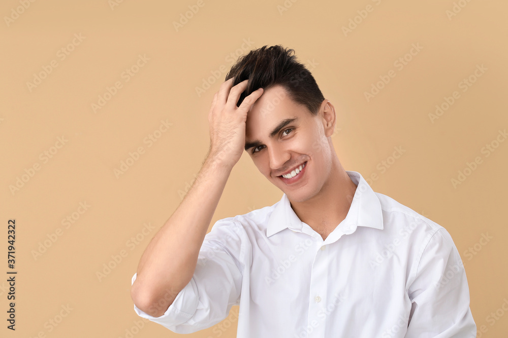 Handsome man with stylish hairdo on color background