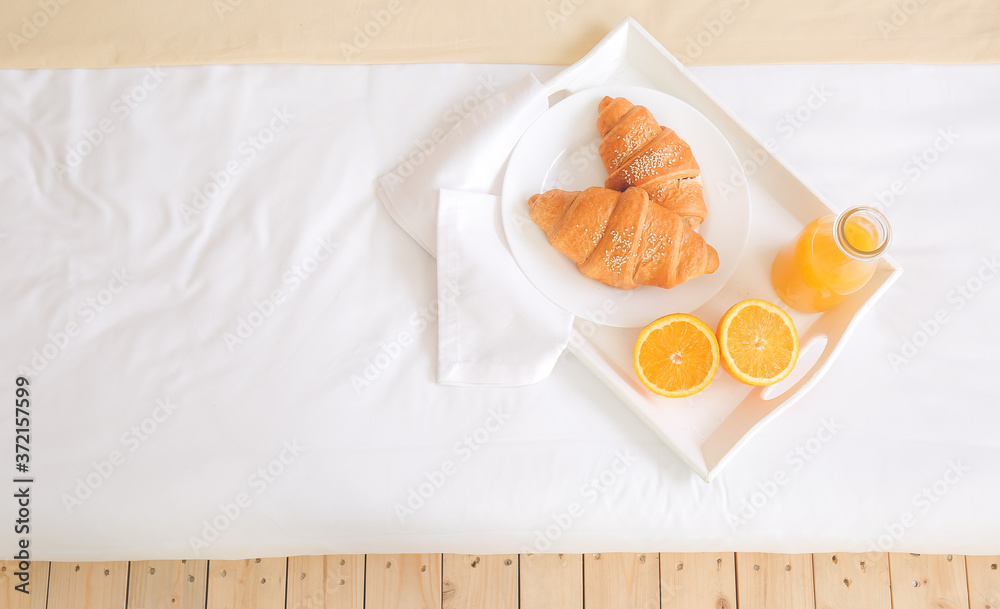 Tasty breakfast on bed in hotel room