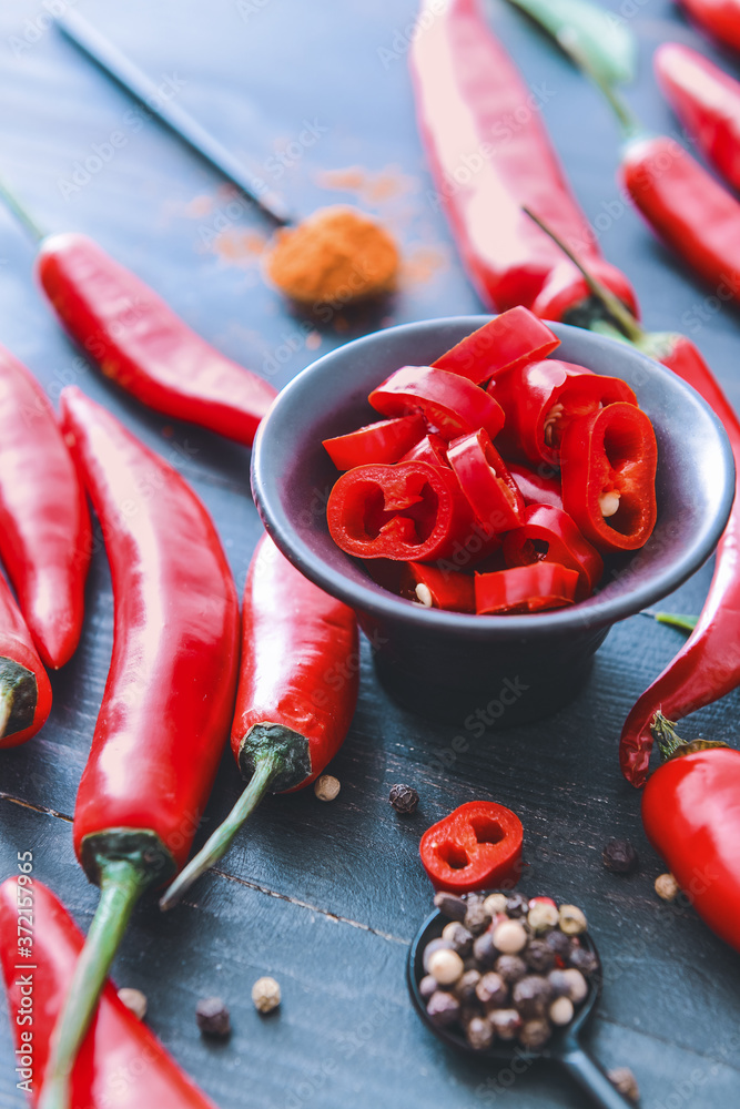 Hot chili pepper with spices on dark wooden background