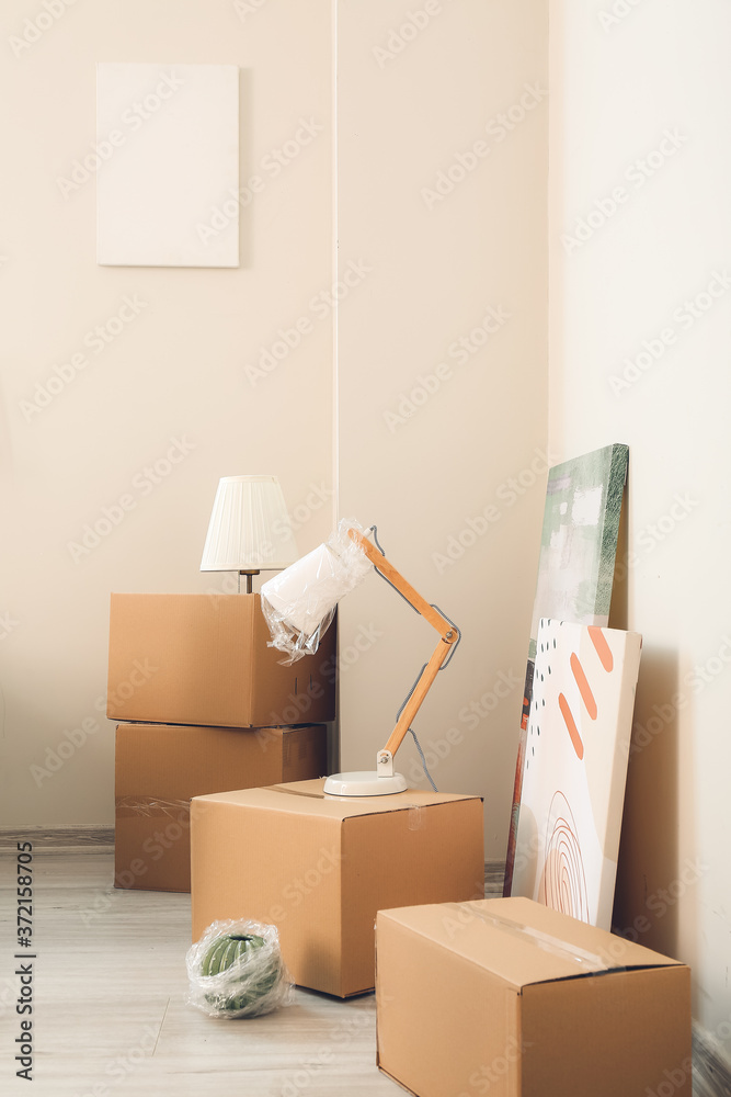 Cardboard boxes with belongings in new flat on moving day