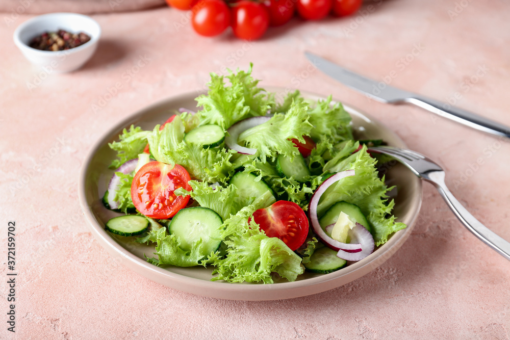 Plate with tasty cucumber salad on color background