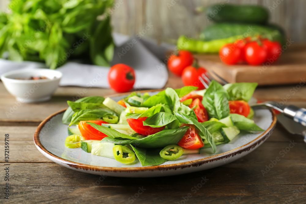 Plate with tasty cucumber salad on table