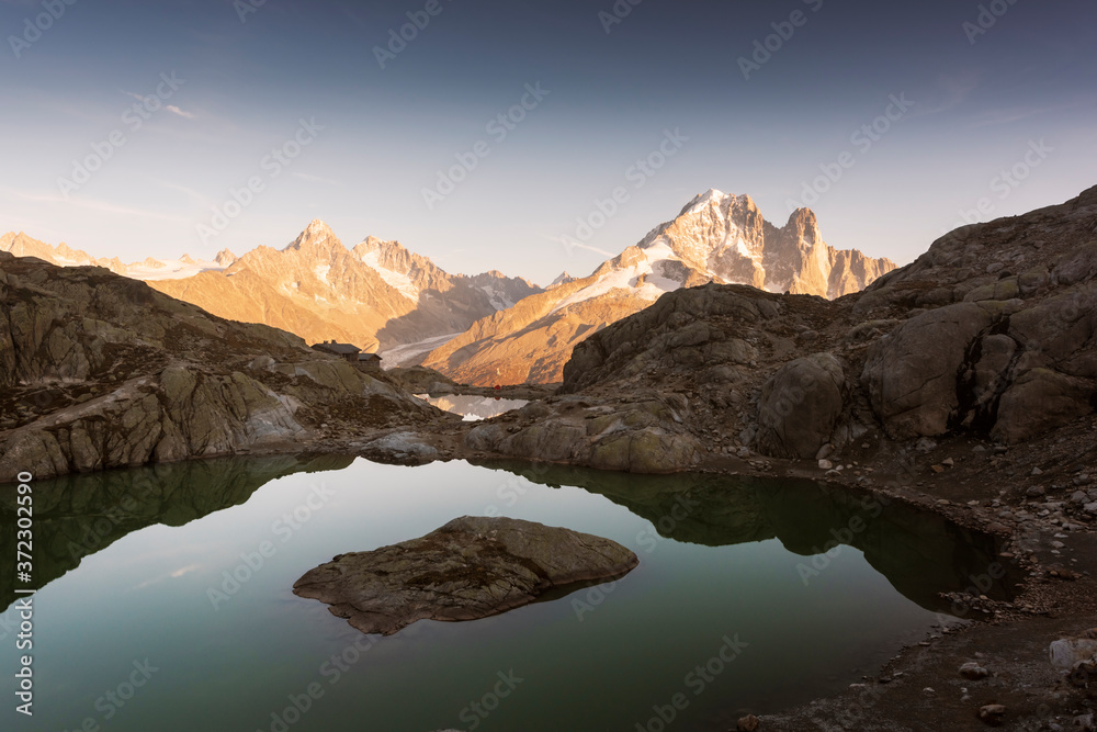 Colourful sunset on Lac Blanc lake in France Alps. Monte Bianco mountain range on background. Vallon