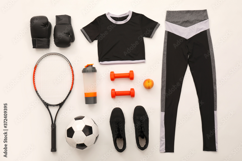 Different sports equipment with clothes on white background