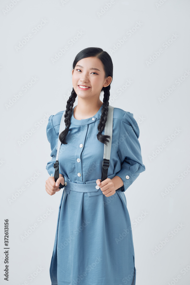 Portrait of a happy pretty girl with backpack standing isolated over white background