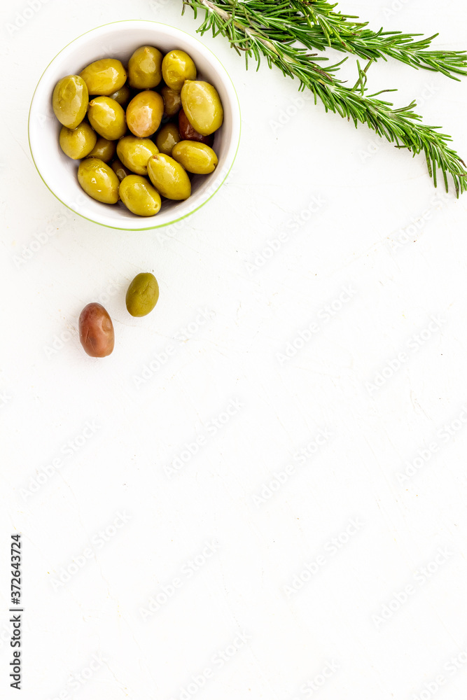 Appetizer. Green and black olives in bowl, rosemary top view space for text