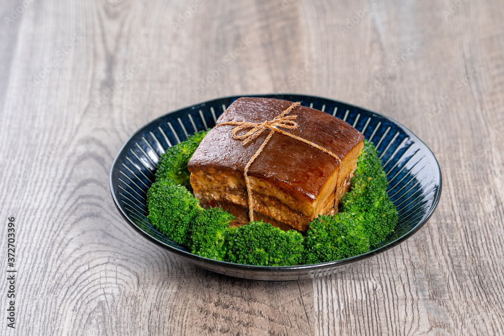 Dong Po Rou (Dongpo pork meat) in a beautiful blue plate with green broccoli vegetable, traditional 