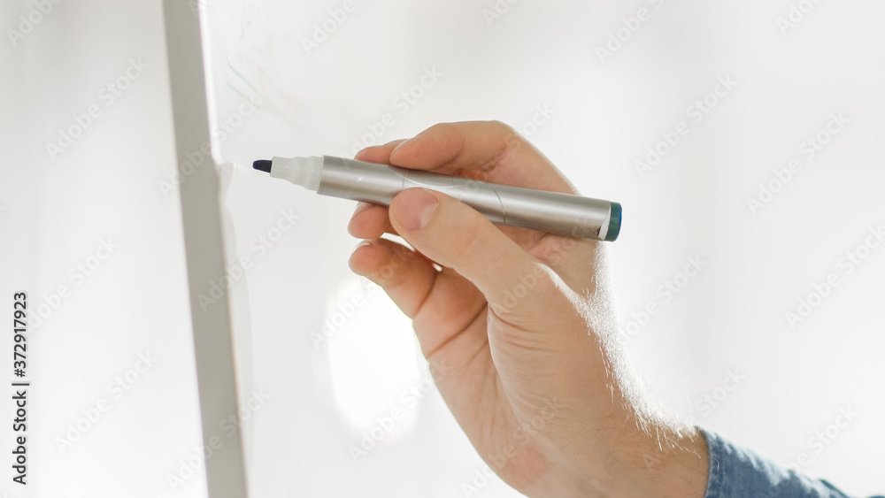 Close-up Shot of a Male Developers Hand Drawing Charts on a Whiteboard. Bright Modern High Tech Offi