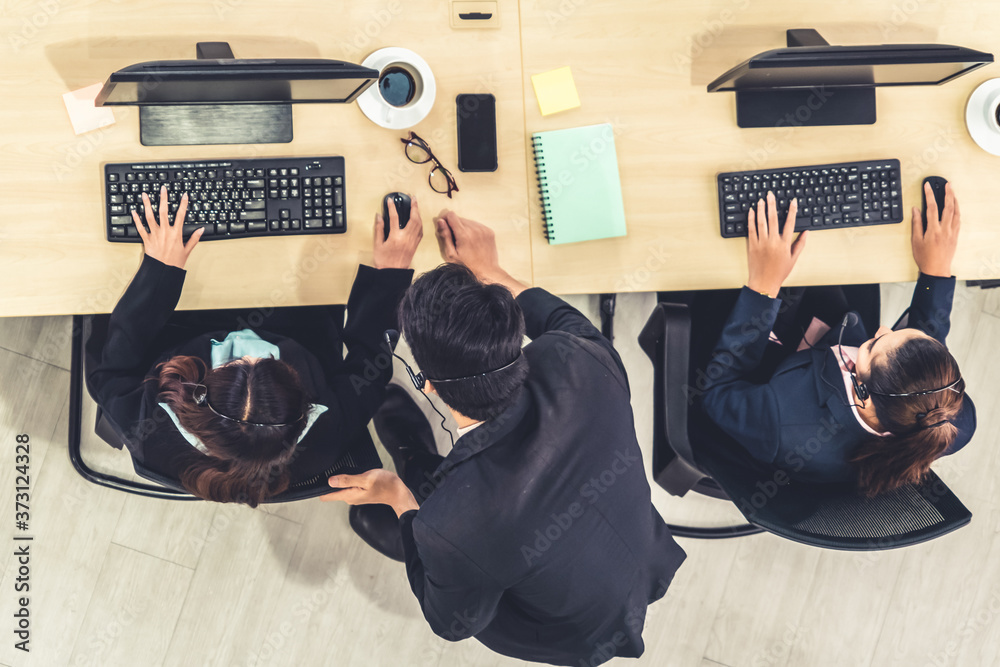 Business people wearing headset from top view in office working with computer to support remote cust