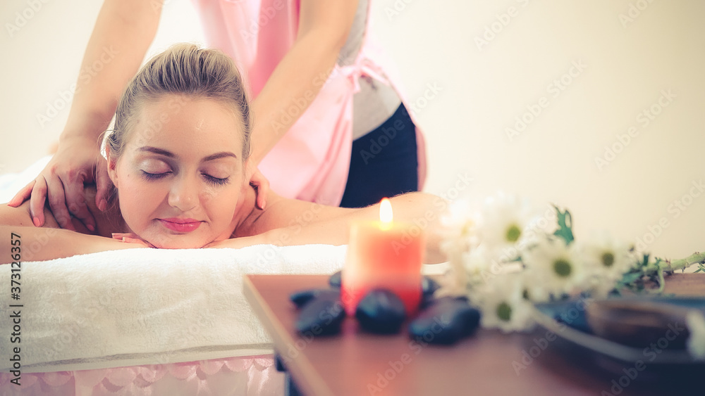 Relaxed woman getting back massage in luxury spa with professional massage therapist. Wellness, heal