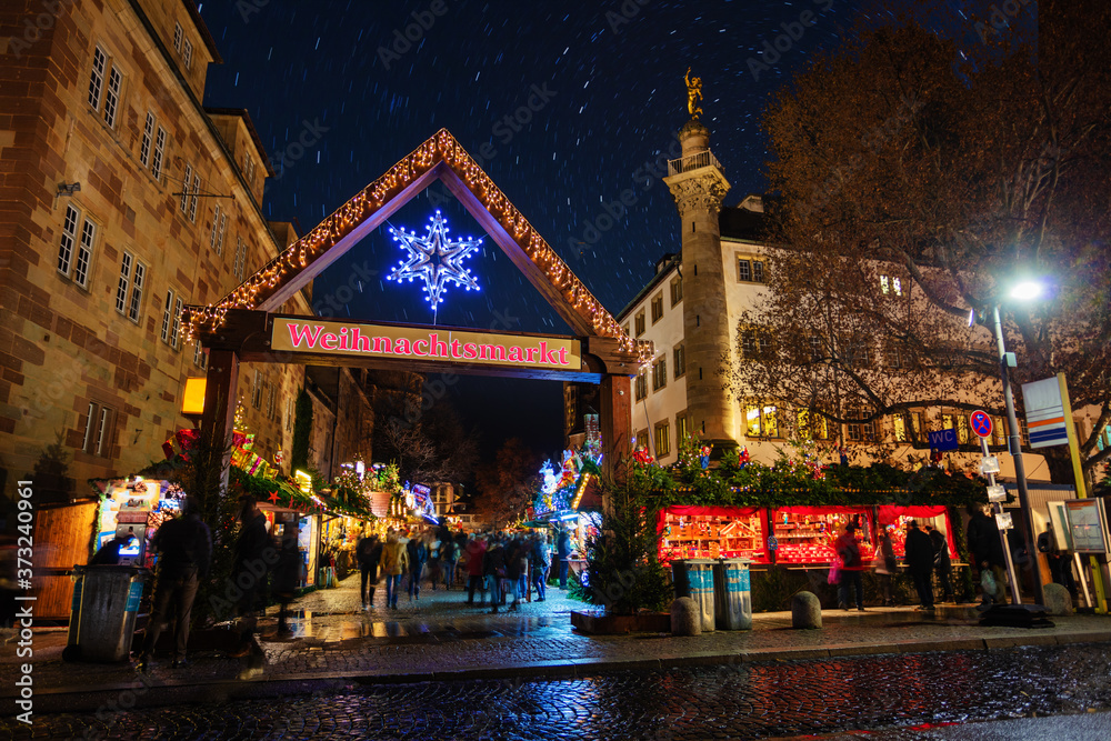 Old Castle and Christmas market gates with sign Weihnachtsmarkt in German at night in Stuttgart