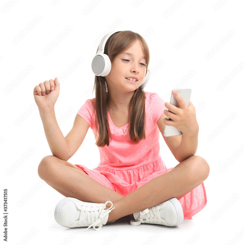 Little girl listening to music on white background