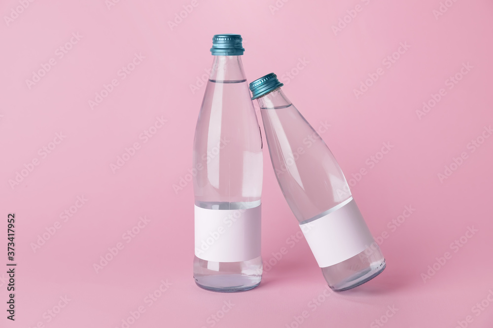 Bottles of clean water on color background