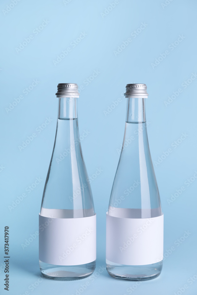 Bottles of clean water on color background