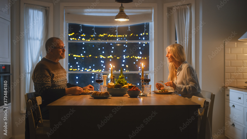 幸福相爱的老年夫妇度过浪漫的夜晚，在厨房吃美味的饭菜，庆祝安宁