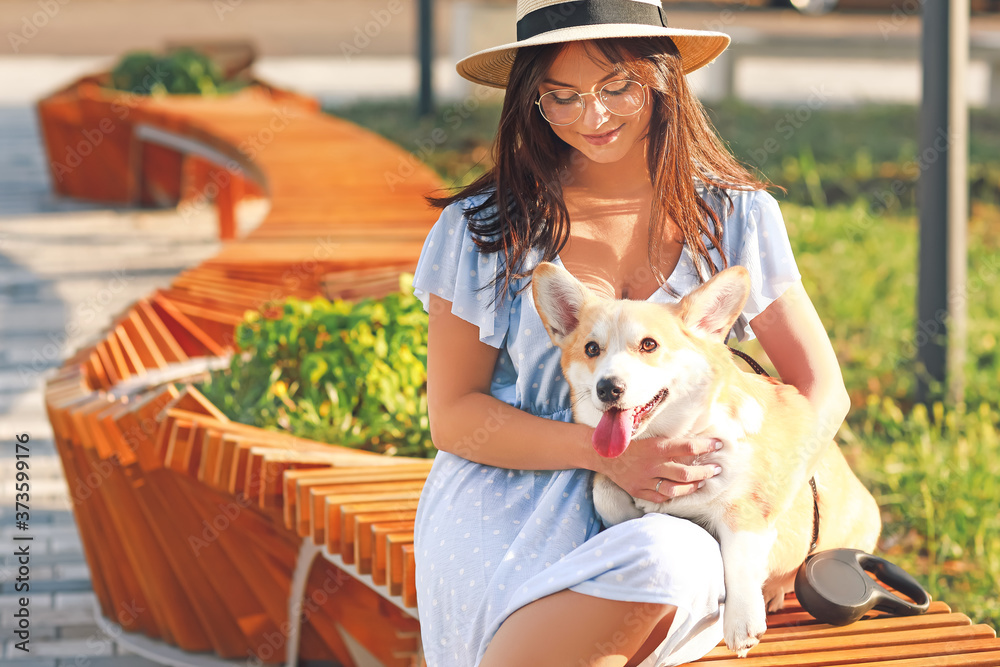 带着可爱的柯基犬在户外散步的女人