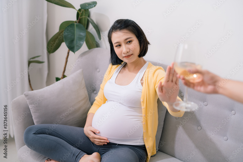 怀孕期间禁止饮酒。年轻孕妇拒绝饮酒，向眼镜做停止手势