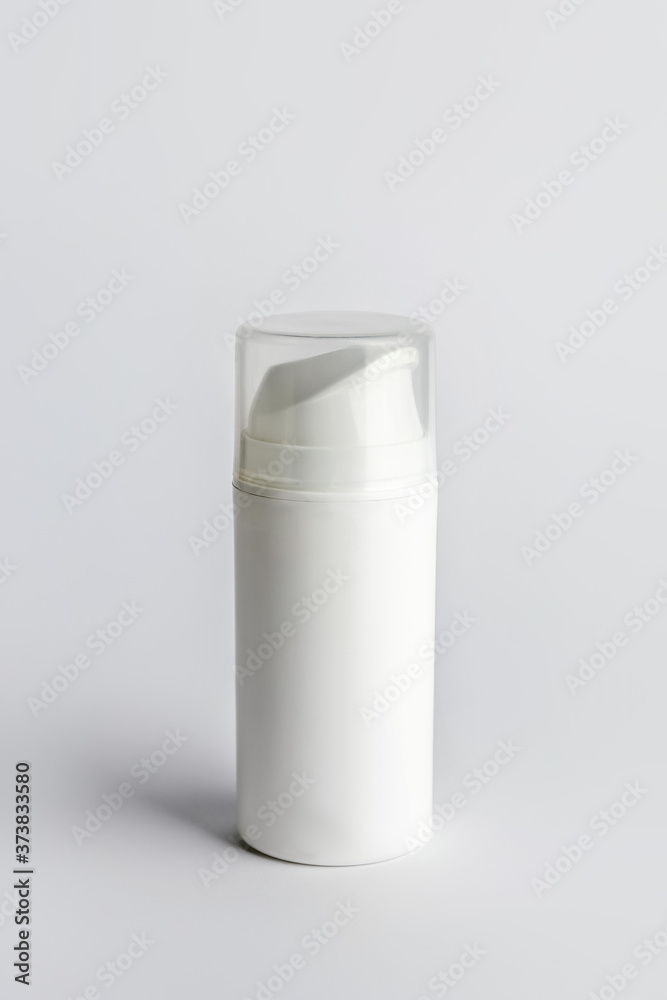 Bottle with cosmetic product on light background