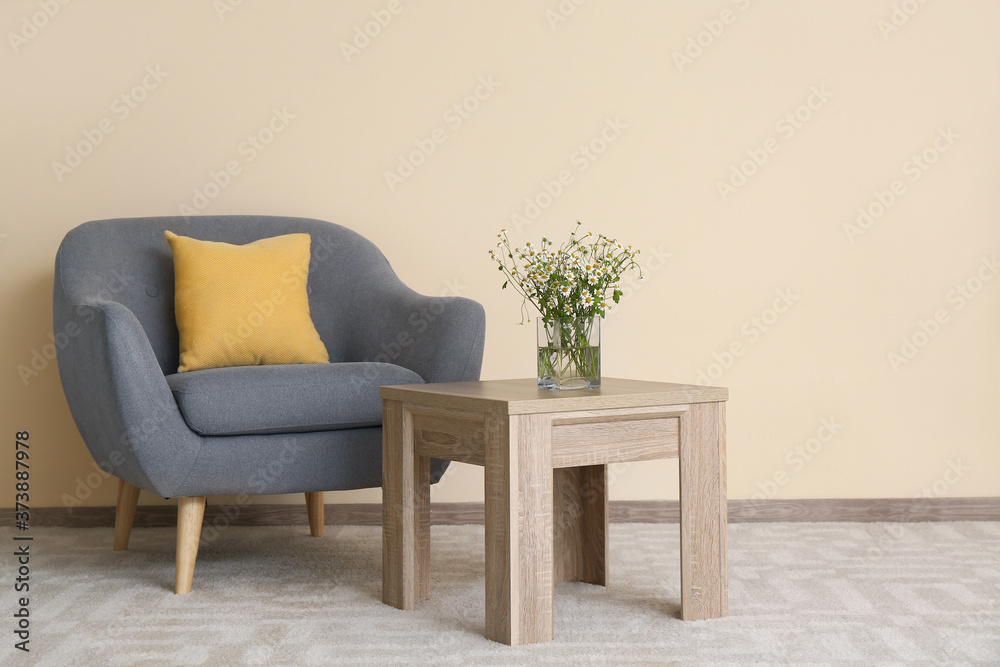 Stylish interior of living room with table and armchair