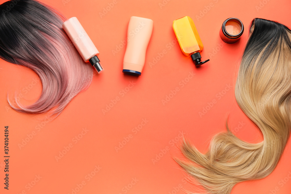 Wigs and different cosmetics for hair on color background