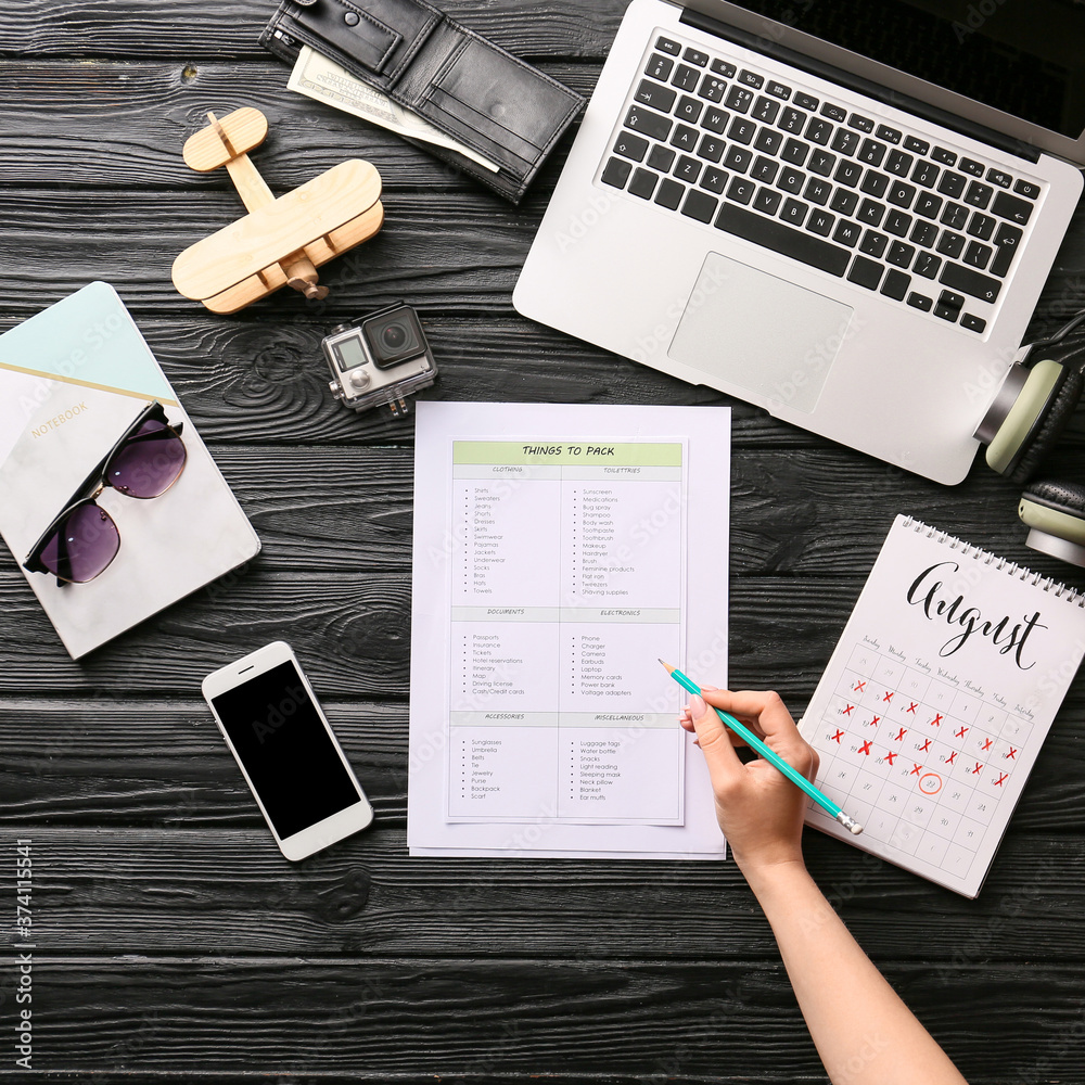 Woman making check-list of things to pack for travel