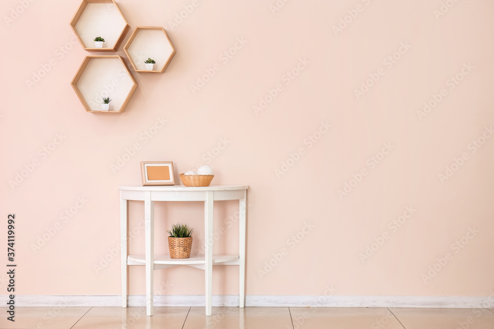 Table with decor near color wall in room