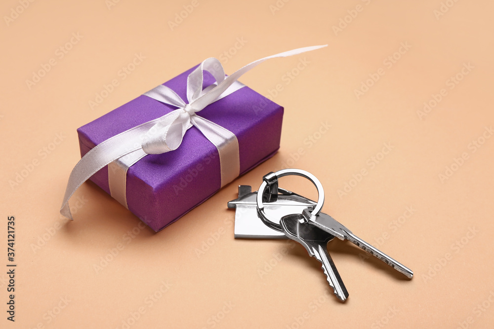 Gift box with keys from house on color background