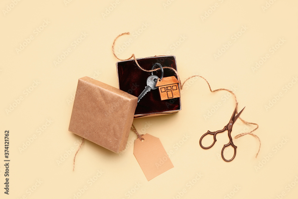 Gift box with key from house on color background