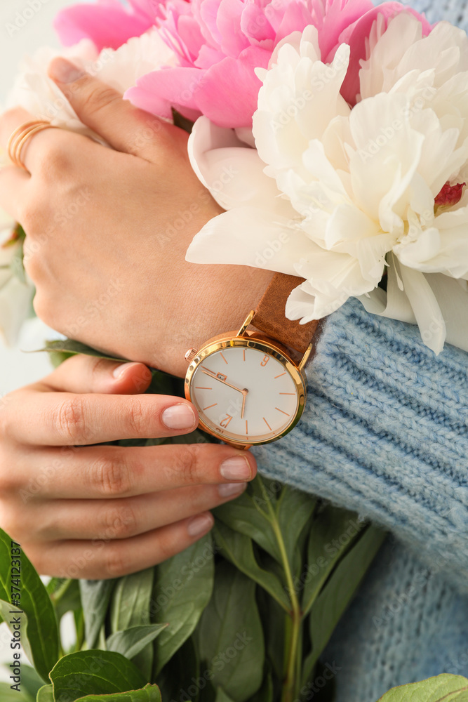 Woman with stylish wrist watch and peony flowers, closeup